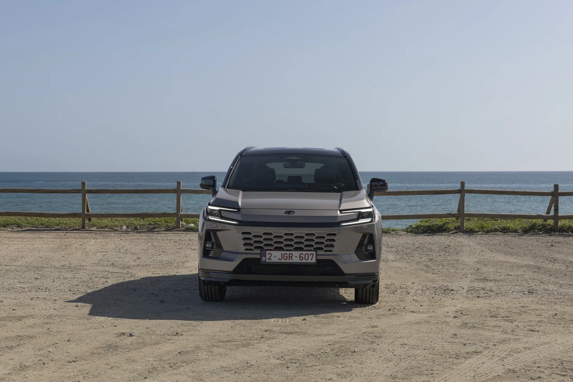Toyota RAV4 VI 2025 exteriér pohled zepředu u mořského pobřeží, šedé barvy, výrazná mřížka a LED světlomety, značky Toyota a modelu RAV4 VI.